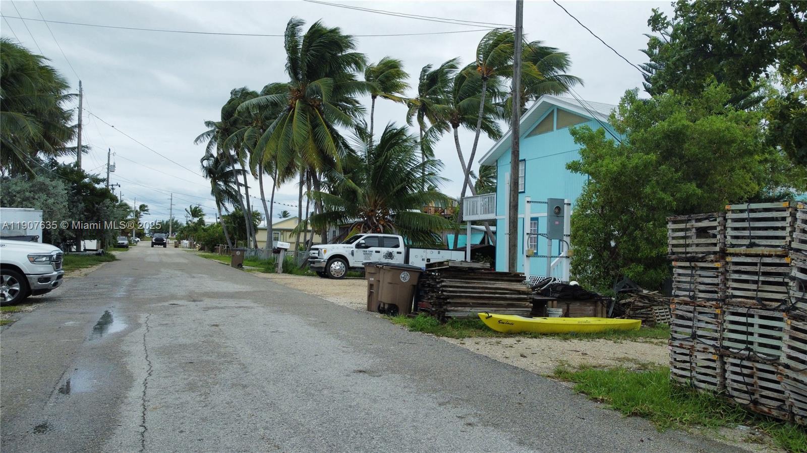 A street view shows a light blue house, palm trees, a yellow kayak, and lobster traps — 93 N Conch Ave, Marathon FL 33050, MARATHON, FL