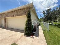 A front porch features a red door, a brick accent wall, and a metal bench — 231 STRATHMORE CIRCLE, KISSIMMEE, FL