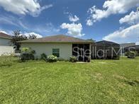 A spacious living area features light-colored wood-look tile flooring and a ceiling fan — 231 STRATHMORE CIRCLE, KISSIMMEE, FL