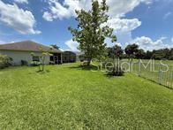 An open-concept living area features wood-look tile flooring, a ceiling fan, and a kitchen — 231 STRATHMORE CIRCLE, KISSIMMEE, FL