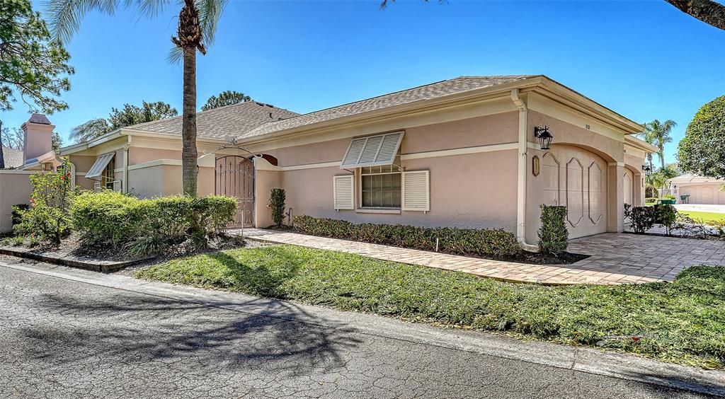 A single-story house with a beige stucco exterior, a tiled walkway, and a garage — 5521 CHANTECLAIRE UNIT 21, SARASOTA, FL