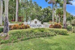 A stone monument sign for Vizcaya stands in a landscaped garden with palm trees — 15334 Fiorenza Circle, Delray Beach FL 33446, DELRAY BEACH, FL