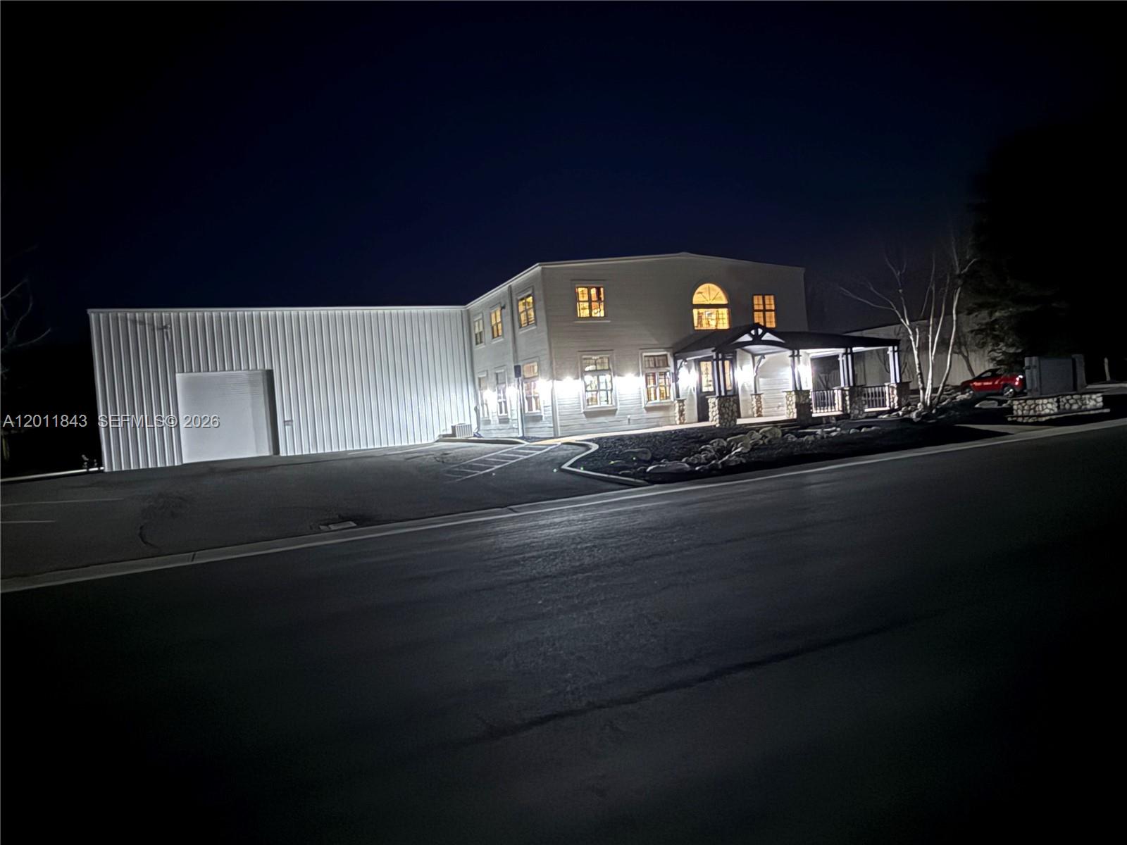A two-story building with a metal-sided warehouse section and a lit front porch at night — 428 NORTH CURRY STREET # 0, CA 93561, CA