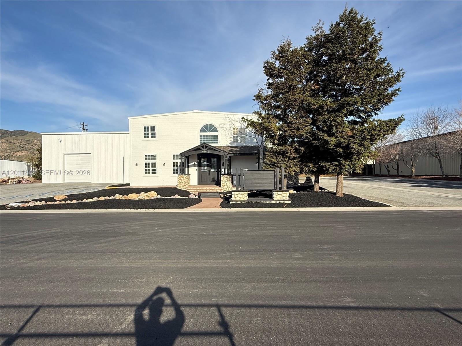 A two-story white building with a stone-accented entrance and a large adjacent warehouse — 428 NORTH CURRY STREET # 0, CA 93561, CA