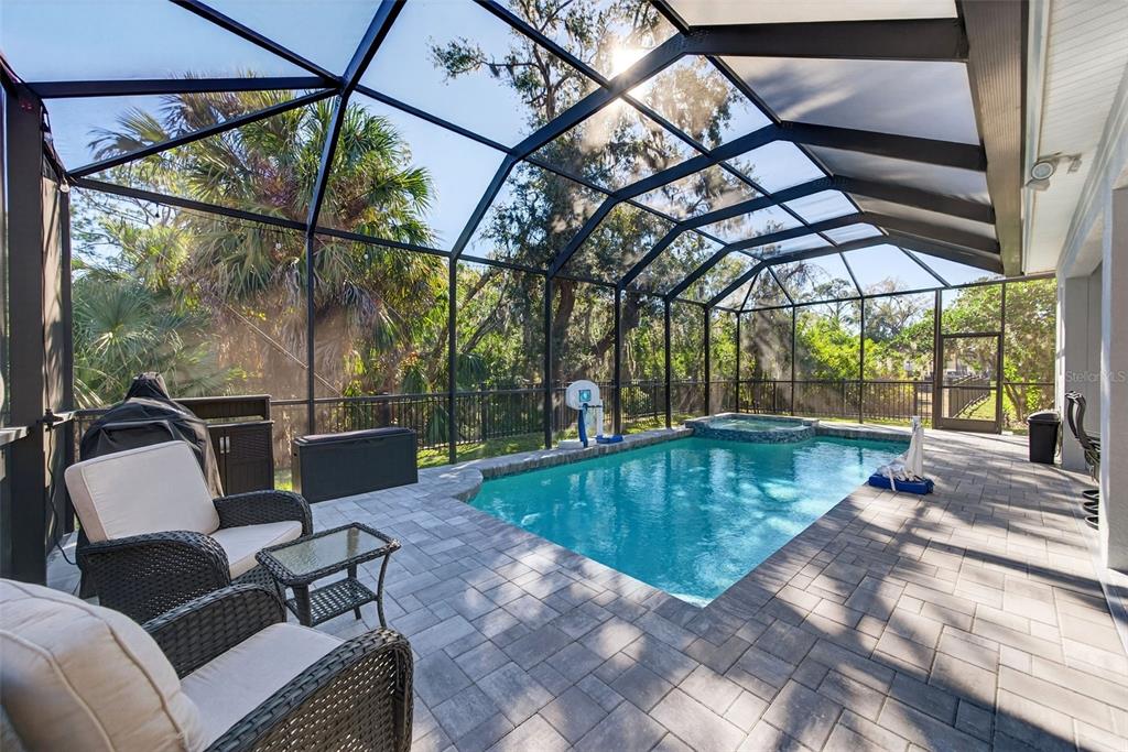 A screened-in patio features a swimming pool, a hot tub, and outdoor wicker furniture — 8111 SANTA ROSA COURT, SARASOTA, FL