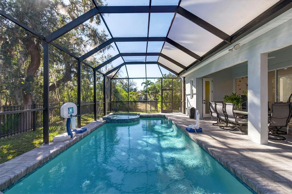 A screened-in swimming pool and spa with a paved deck and outdoor dining area — 8111 SANTA ROSA COURT, SARASOTA, FL