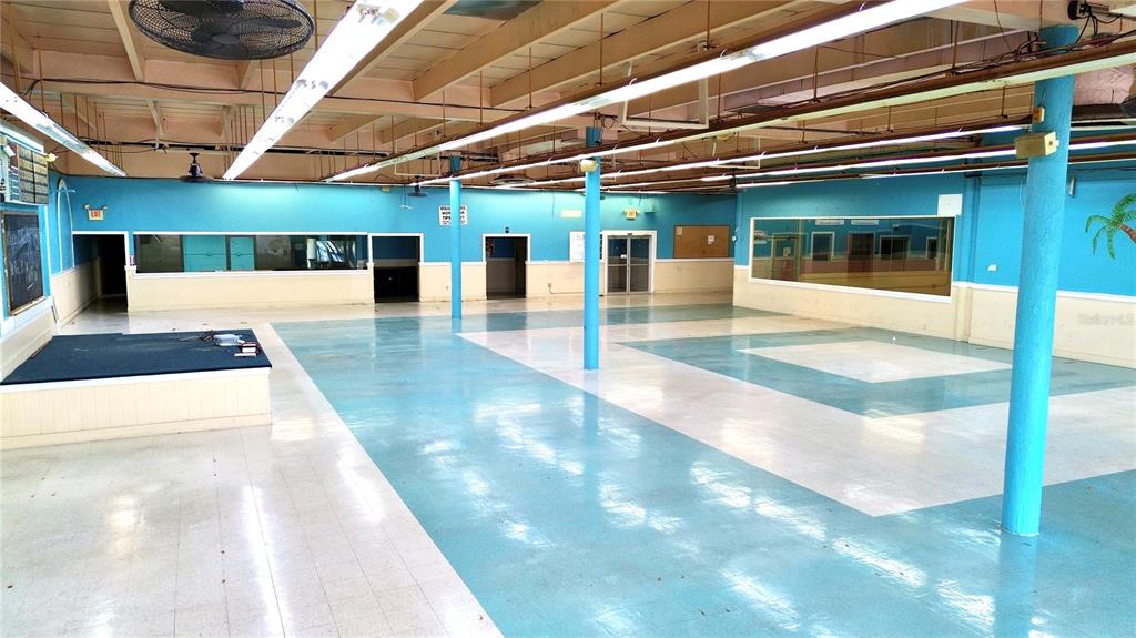 A large, open commercial space features blue and white tiled flooring and exposed ceiling beams — 1091 W MAIN STREET, AVON PARK, FL