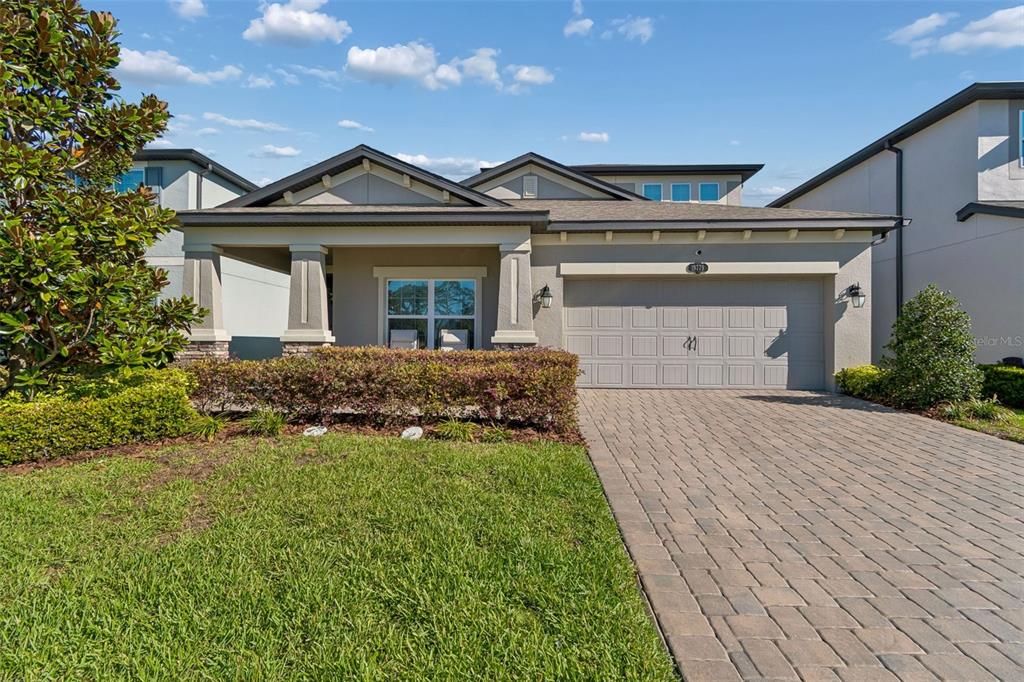 A single-story house with a paved driveway, a two-car garage, and a covered front porch — 19779 MORSANI ROAD, LUTZ, FL
