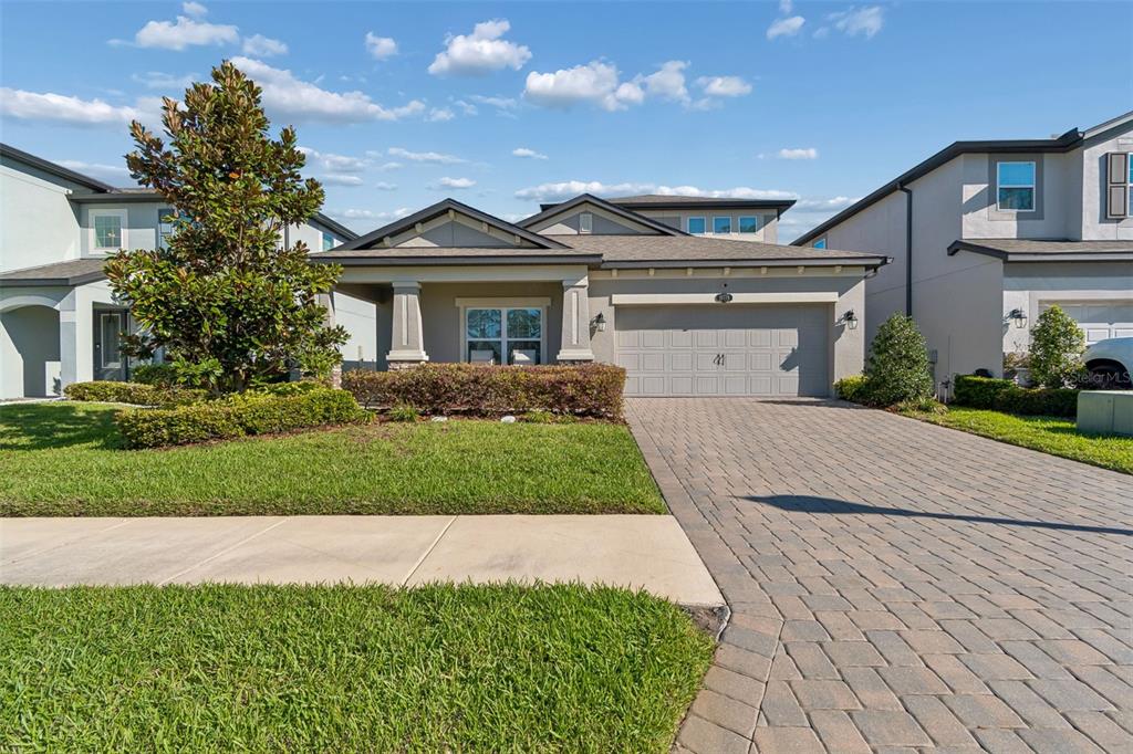 A single-story suburban house with a paved driveway, a two-car garage, and a front lawn — 19779 MORSANI ROAD, LUTZ, FL