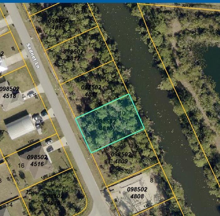 This is an aerial map showing a vacant lot highlighted in blue along a canal — SADNET LANE, NORTH PORT, FL