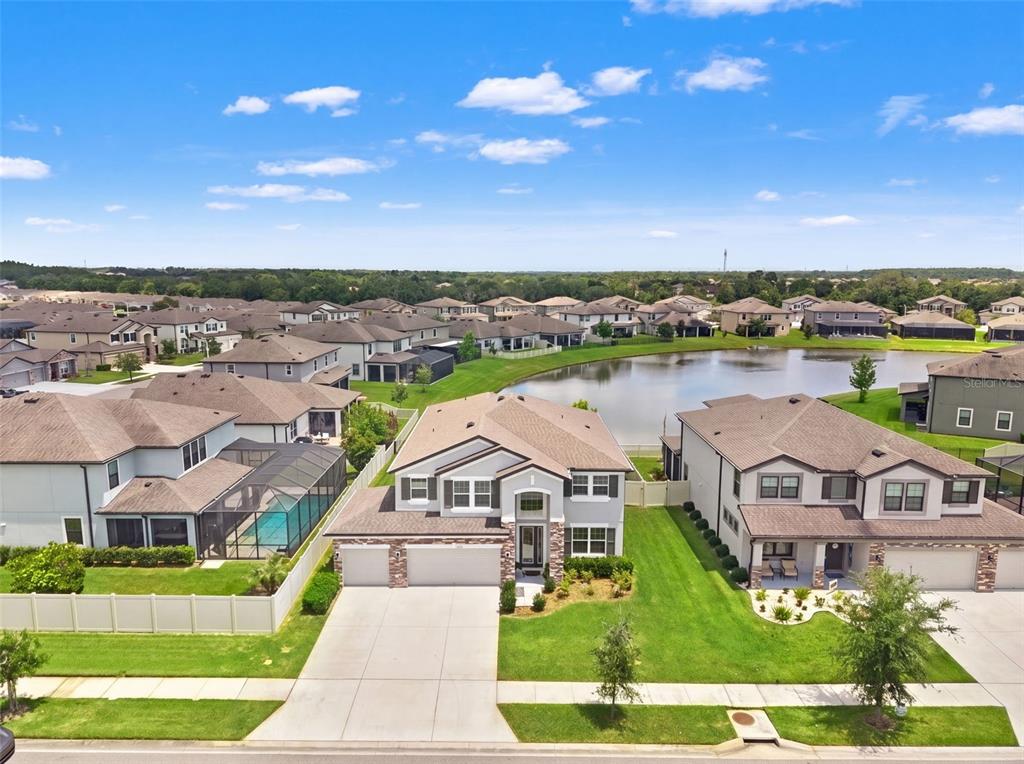 An aerial view of a suburban house with a pool and a pond in back — 7648 SWEETER TIDE TRAIL, WESLEY CHAPEL, FL