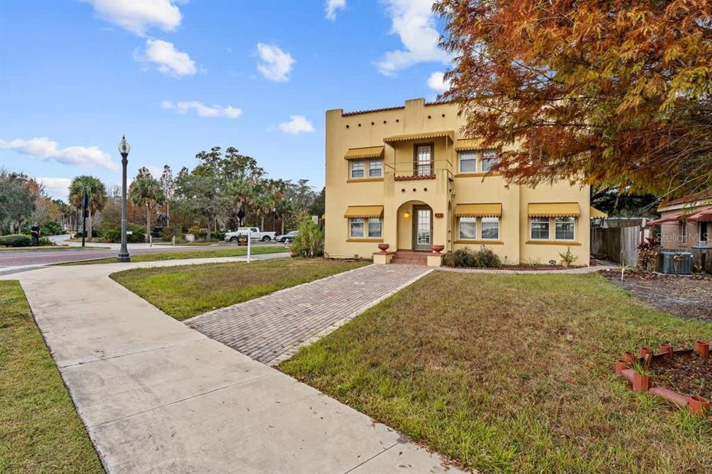 A two-story yellow stucco building with a brick driveway and a flat roof — 304 LAKESHORE BOULEVARD, KISSIMMEE, FL