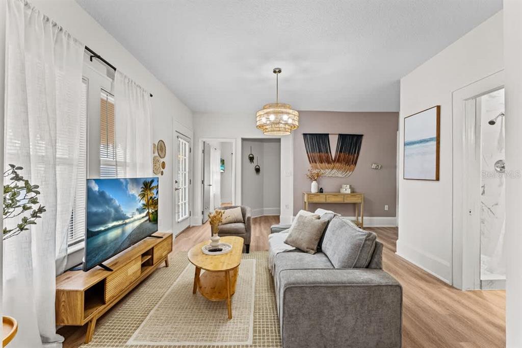 A living room features a grey sofa, wood coffee table, media console, and light flooring — 304 LAKESHORE BOULEVARD, KISSIMMEE, FL