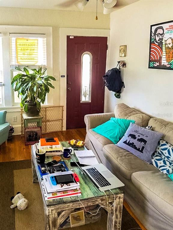 A living room features a wooden coffee table, a beige sofa, and a red front door — 1210 HIGHLAND STREET S, ST PETERSBURG, FL