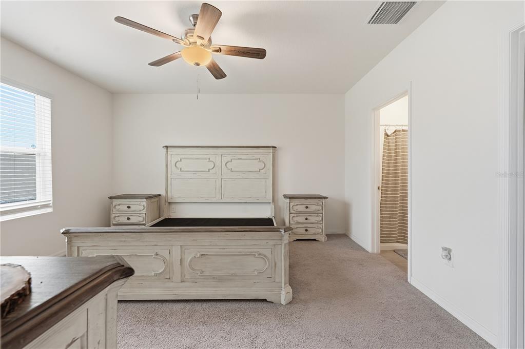 A bedroom features a light-colored wooden bed frame, matching nightstands, and a ceiling fan — 33922 JASPER STONE DRIVE, WESLEY CHAPEL, FL