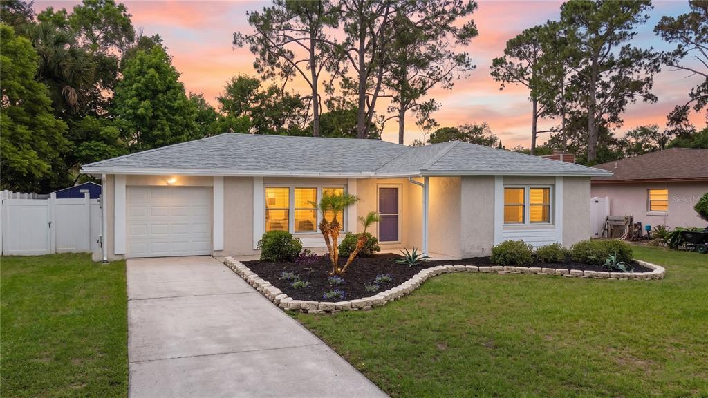 A single-story house with a white garage, a concrete driveway, and a landscaped front yard — 125 BLUEFISH AVENUE, PONTE VEDRA BEACH, FL