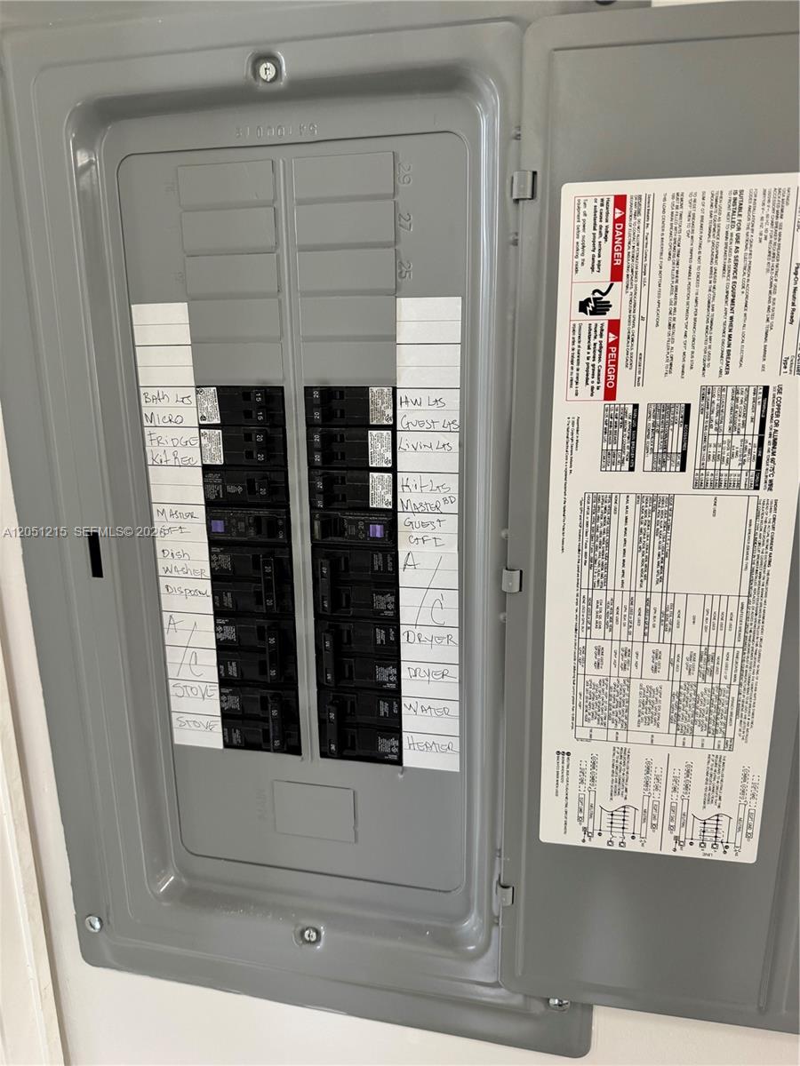 A residential electrical breaker panel with labeled switches is mounted on a white wall — 9937 Three Lakes Cir # 14d, Boca Raton FL 33428, BOCA RATON, FL
