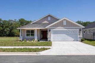 A single-story house with a two-car garage, light siding, and a concrete driveway — 16766 NW 178TH TERRACE, ALACHUA, FL