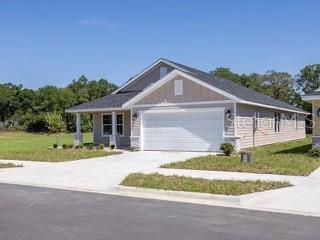 A single-story house with light-colored siding and a two-car garage under a clear sky — 16766 NW 178TH TERRACE, ALACHUA, FL