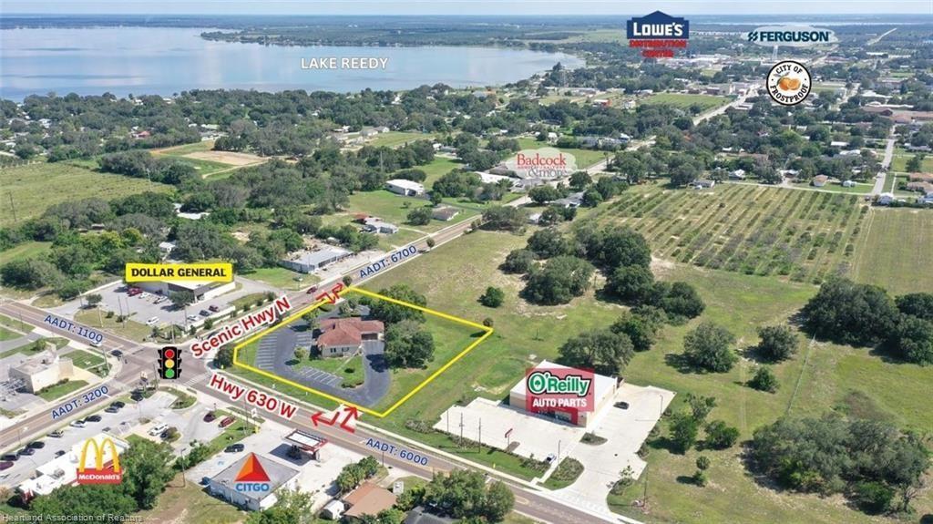 This aerial view shows a commercial property lot outlined in yellow near a road intersection — 695 N Scenic Highway, FL 33843, FL
