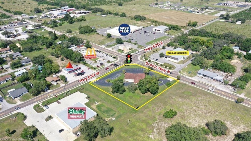 This aerial view shows a commercial property at a road intersection with surrounding businesses — 695 N Scenic Highway, FL 33843, FL