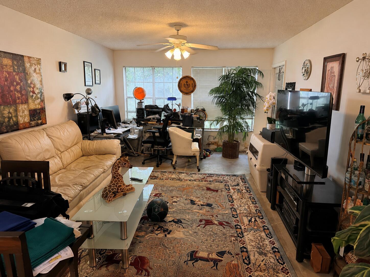 A living room features a beige leather sofa, a patterned area rug, and a home office — 6323 La Costa Drive # B, Boca Raton FL 33433, BOCA RATON, FL