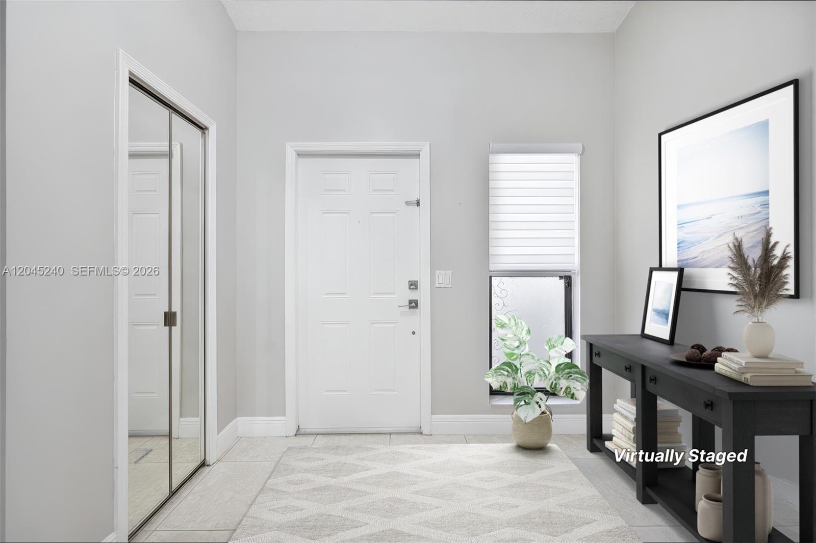An entryway features a white door, a mirrored closet, a window, and a console table — 4870 Hawkes Bluff Ave, Davie FL 33331, DAVIE, FL