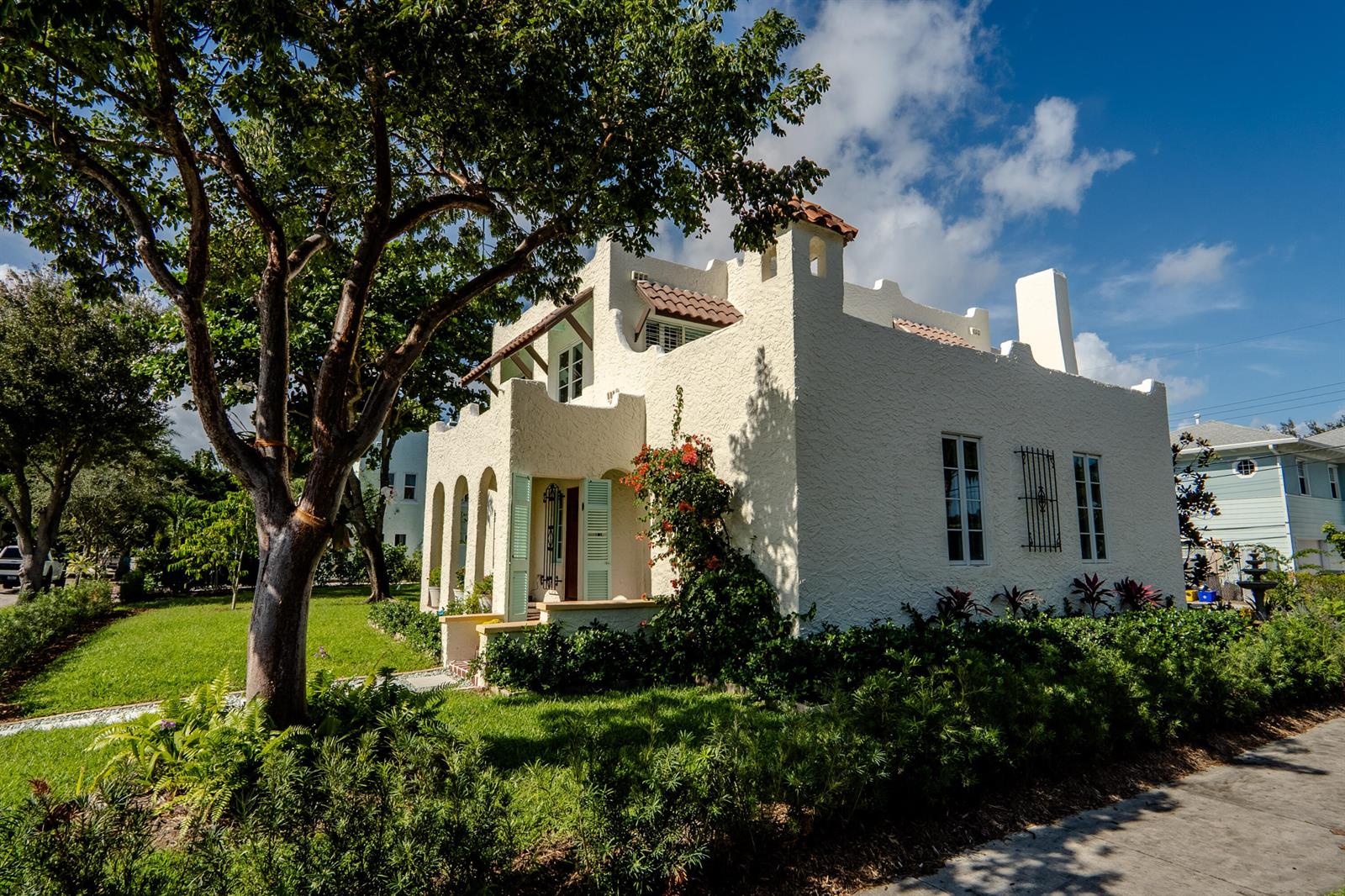 A two-story stucco house with a crenellated roofline and arched porch sits near a tree — 302 Fordham Drive, FL 33460, FL