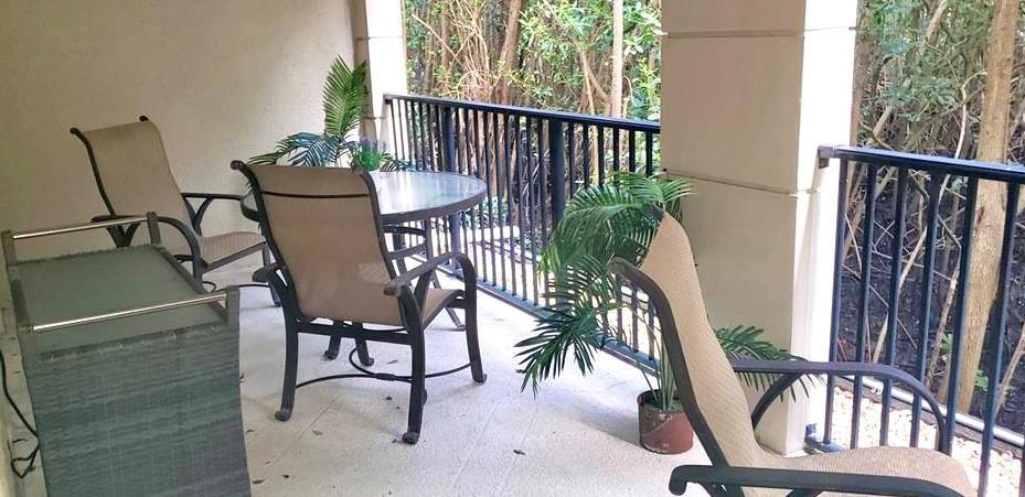 A covered balcony features a small table with two chairs and a separate lounge chair — 4102 Tuscany Way # 4102, Boynton Beach FL 33435, BOYNTON BEACH, FL