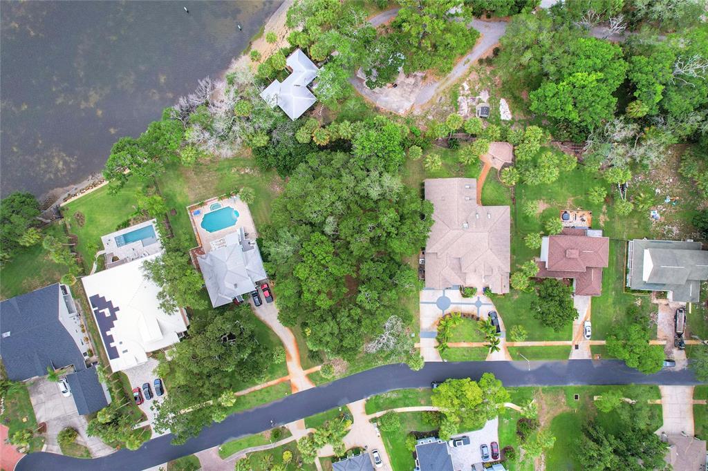Aerial view of several houses with swimming pools and lush landscaping near a lake — Lot 6 MEYERS COVE DRIVE, TARPON SPRINGS, FL