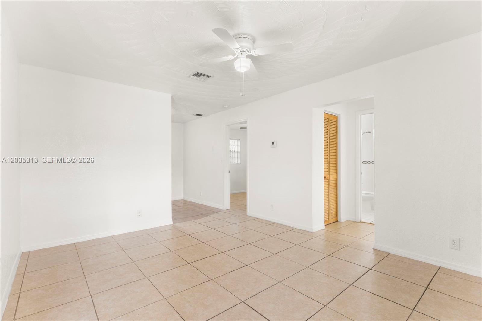 A bright, empty room features white walls, tan tile flooring, and a ceiling fan — 4120 SW 19th St # 2, West Park FL 33023, WEST PARK, FL