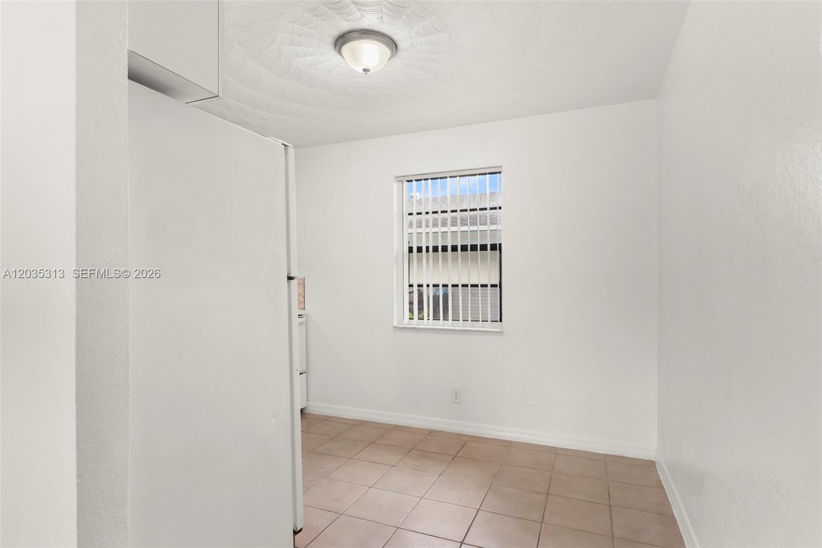A small, empty room features white walls, a tiled floor, and a single window — 4120 SW 19th St # 2, West Park FL 33023, WEST PARK, FL