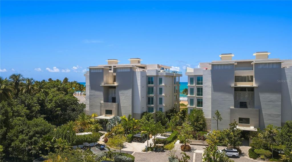An exterior view of two modern multi-story residential buildings surrounded by lush tropical landscaping — 7000 BAHIA BEACH BOULEVARD UNIT Ocean Drive 3301, RIO GRANDE, PR