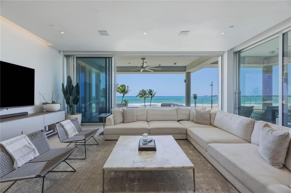 A modern living room features a large sectional sofa, marble coffee table, and ocean views — 7000 BAHIA BEACH BOULEVARD UNIT Ocean Drive 3301, RIO GRANDE, PR