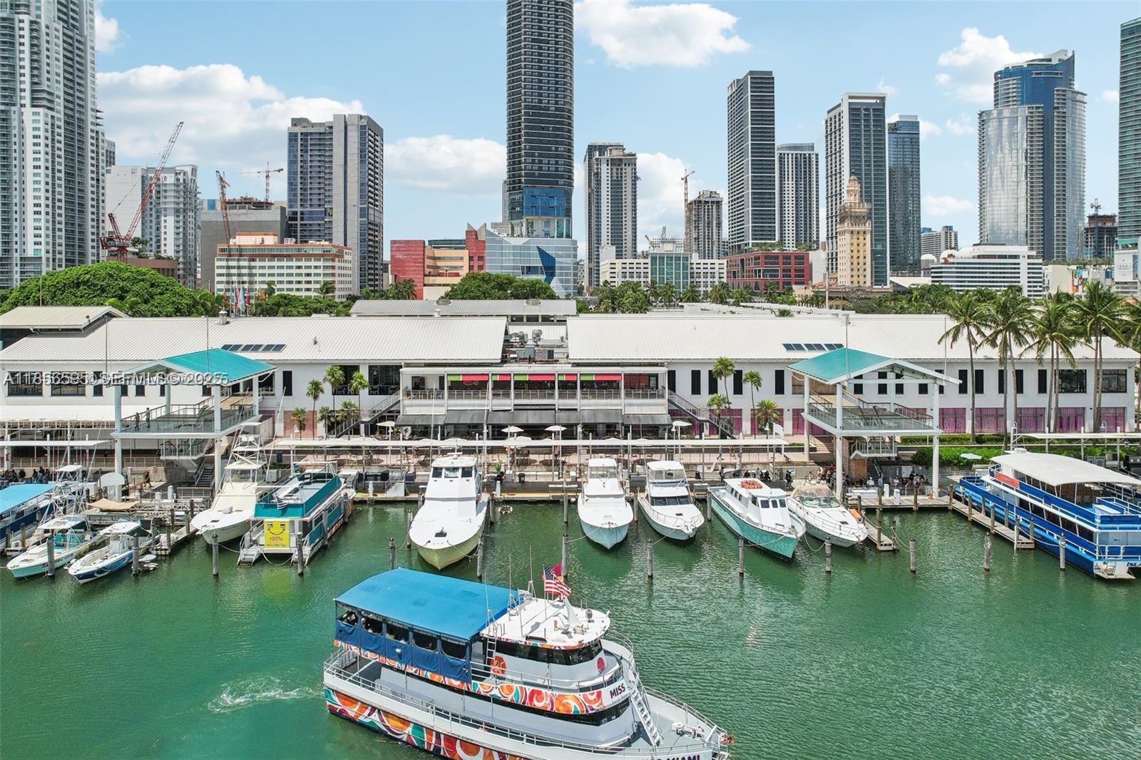 An aerial view shows a marina with several boats docked in front of a waterfront building — 398 NE 5th St # 4415, Miami FL 33132, MIAMI, FL