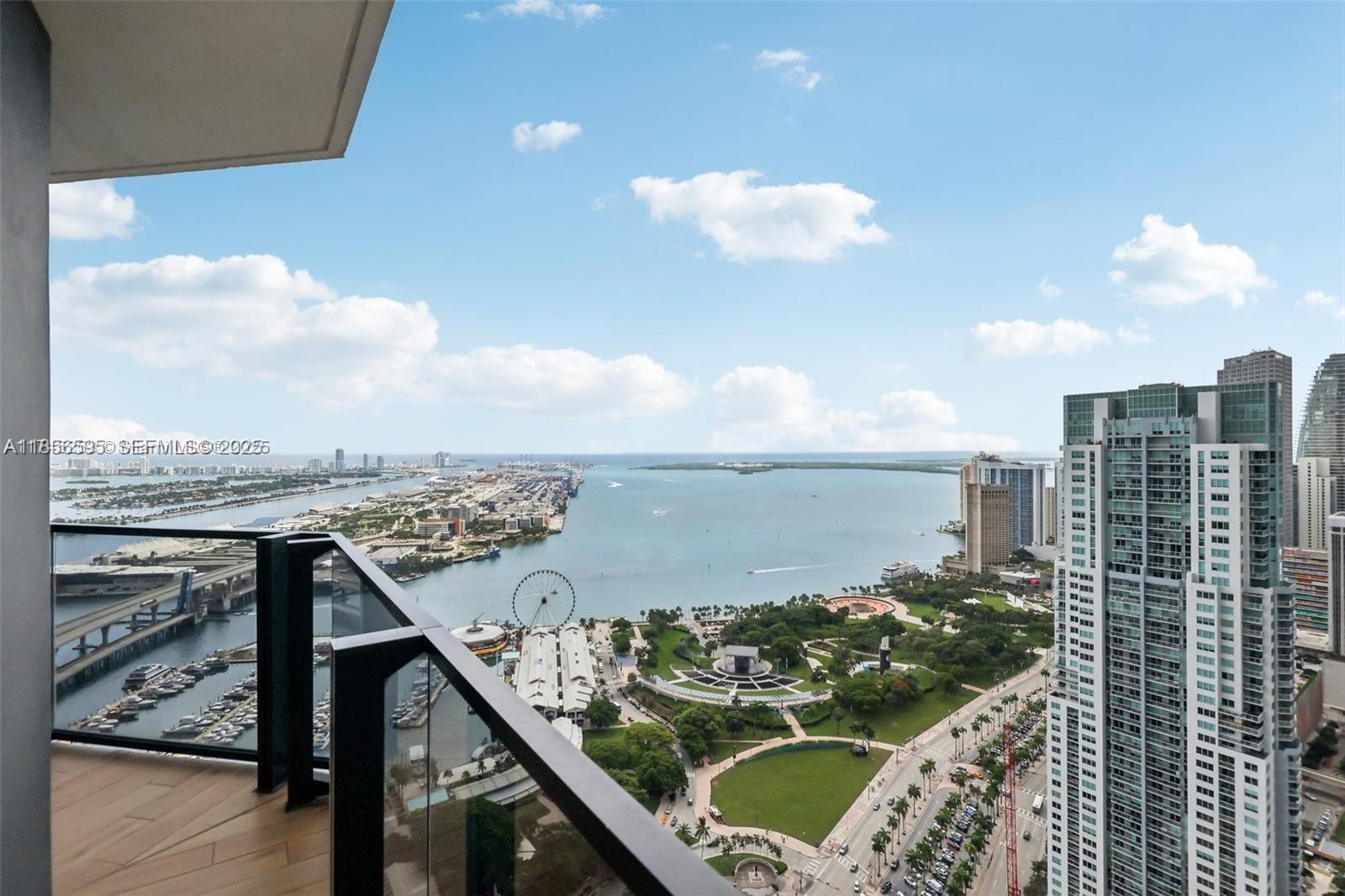 A high-rise balcony overlooks a bay, a park, a Ferris wheel, and city skyscrapers — 398 NE 5th St # 4415, Miami FL 33132, MIAMI, FL