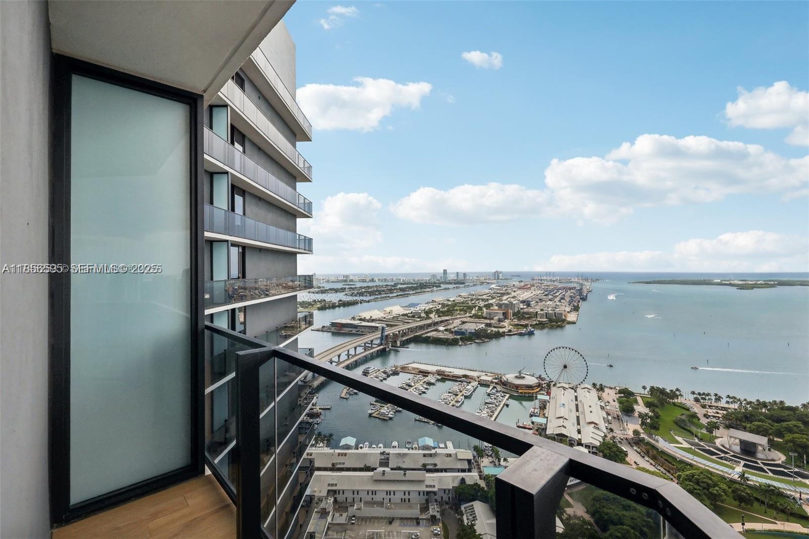 A high-rise balcony overlooks a harbor, a bridge, a Ferris wheel, and the ocean — 398 NE 5th St # 4415, Miami FL 33132, MIAMI, FL