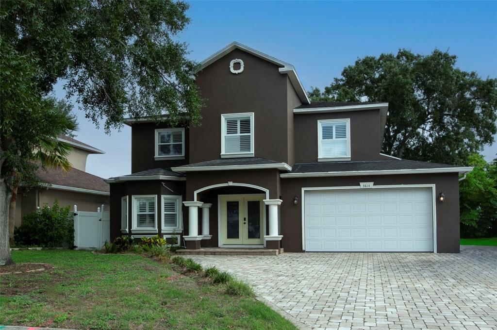 A two-story dark brown house with a white garage door and a paved driveway — 3814 W EL PRADO BOULEVARD, TAMPA, FL