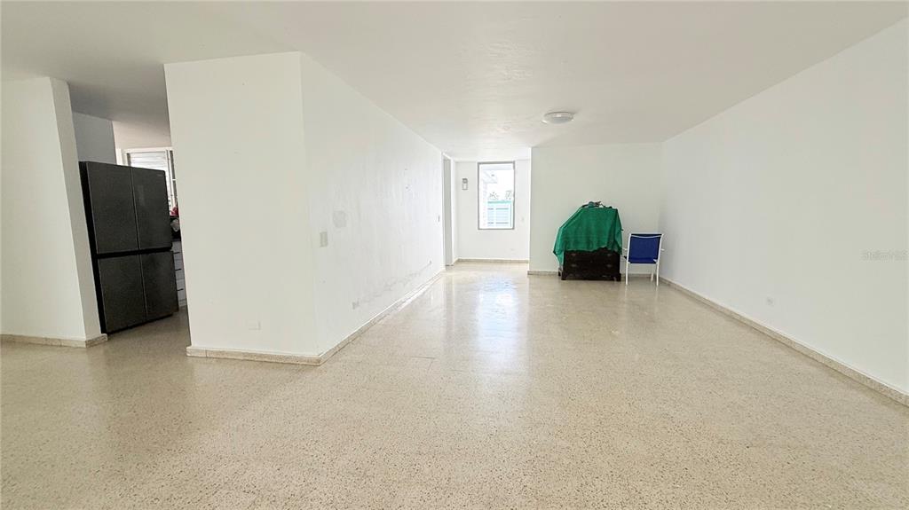 An open-concept living area features white walls, light-colored terrazzo flooring, and a black refrigerator — 4-3 PASEO DE LA ALHAMBRA, GUAYNABO, PR