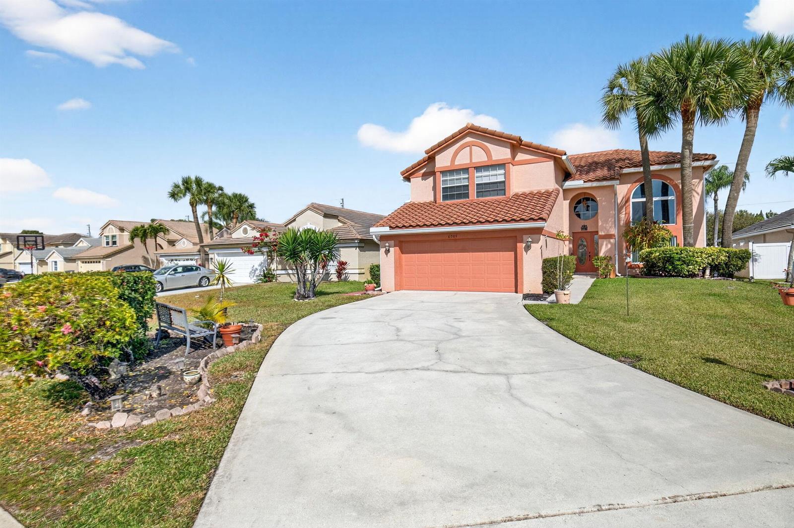 A two-story stucco house with a tile roof and a concrete driveway under a blue sky — 6205 Balmy Court, Boynton Beach FL 33472, BOYNTON BEACH, FL