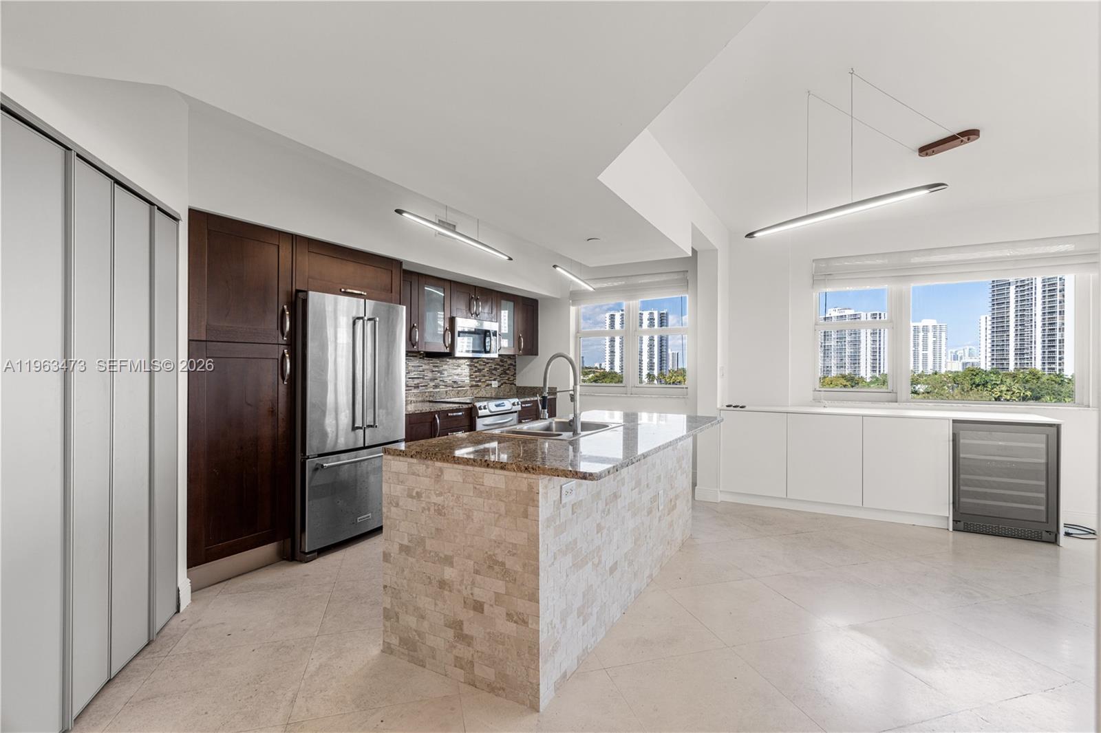 A modern bedroom features a platform bed, vertical wood wall paneling, and a circular chandelier — 20000 E Country Club Dr # 716, Aventura FL 33180, AVENTURA, FL