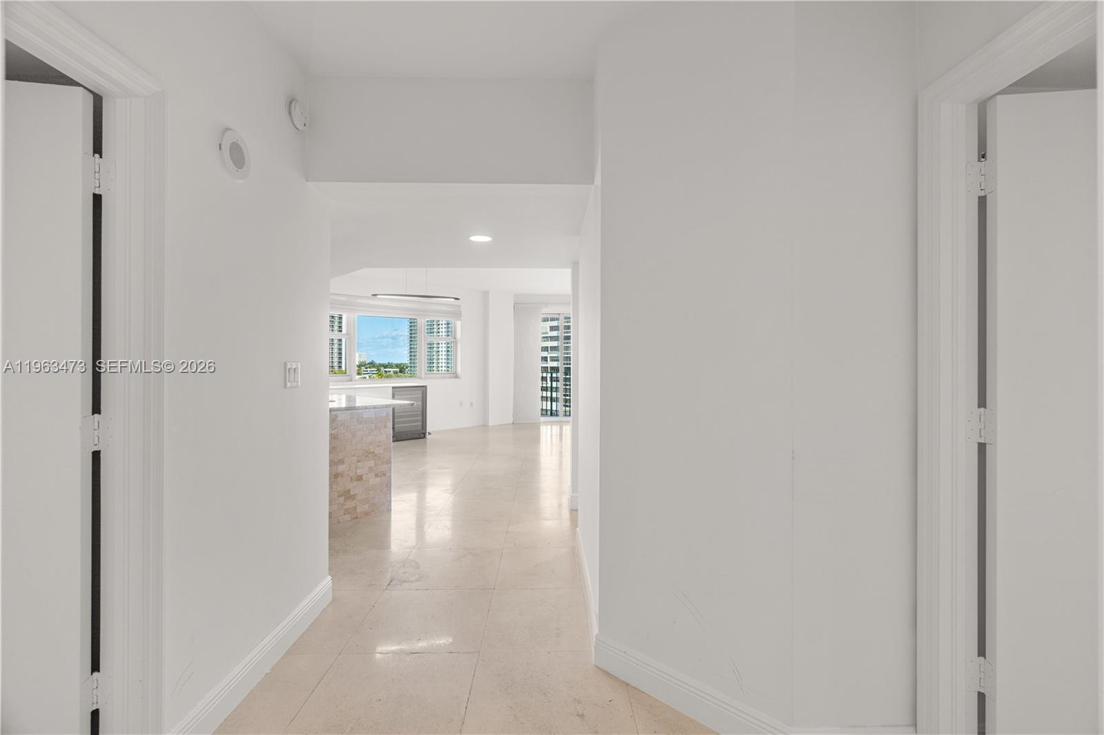 A kitchen features dark wood cabinets, a stone-topped island, and white lower cabinetry — 20000 E Country Club Dr # 716, Aventura FL 33180, AVENTURA, FL