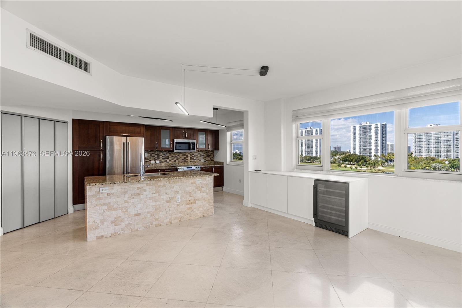 A balcony view overlooks a lake surrounded by a golf course and high-rise buildings — 20000 E Country Club Dr # 716, Aventura FL 33180, AVENTURA, FL