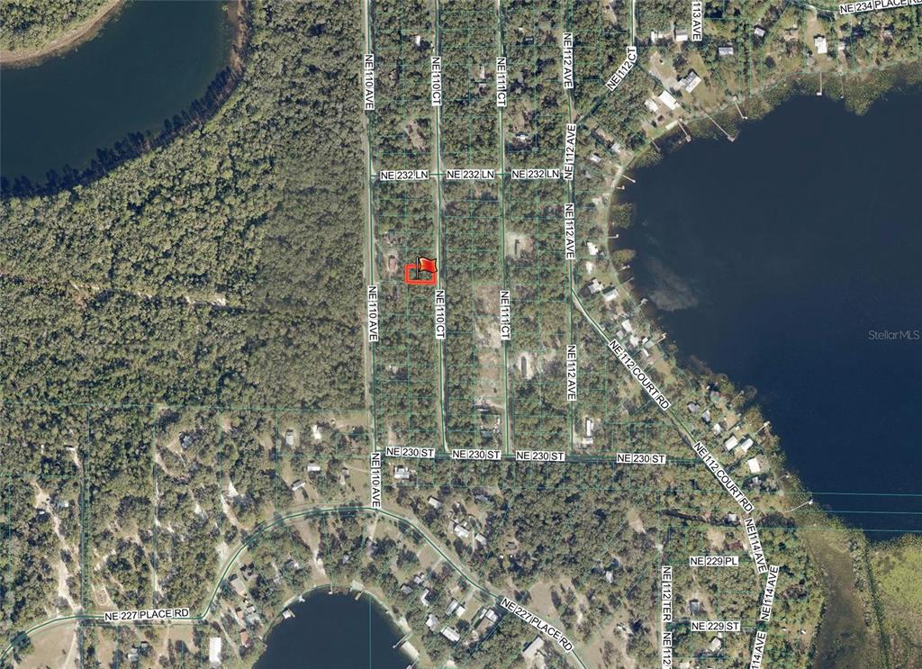 This is an aerial map showing a residential lot highlighted in red — TBD NE 110TH COURT, FORT MC COY, FL
