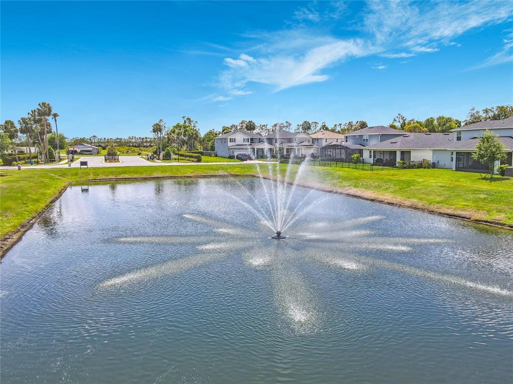 A fountain sprays water in the center of a pond surrounded by suburban houses — 3412 BLUFF OAK LANE, SANFORD, FL