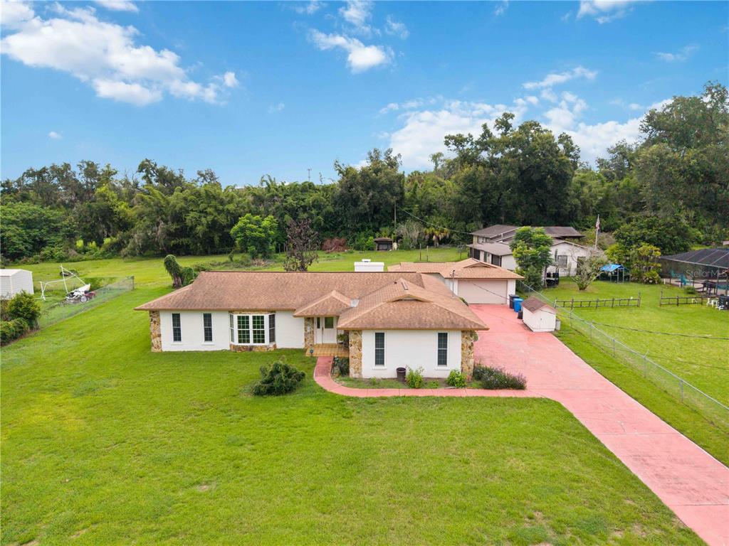 An aerial view of a single-story house with a red driveway and a large yard — 4803 LYNN OAKS CIRCLE, DOVER, FL
