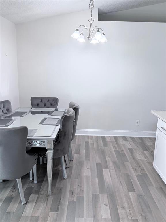 A dining room features a mirrored table, gray tufted chairs, and a chandelier — 3237 LONDON AVENUE, DELTONA, FL