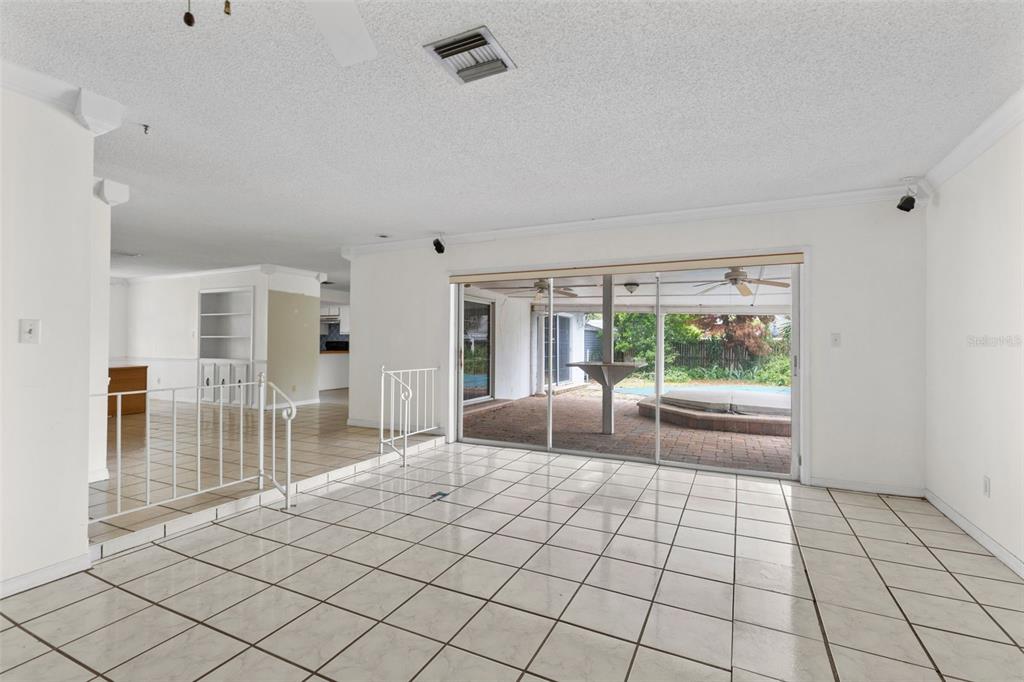 A tiled living room features a white metal railing and sliding glass doors to a patio — 2467 FIELDINGWOOD ROAD, MAITLAND, FL