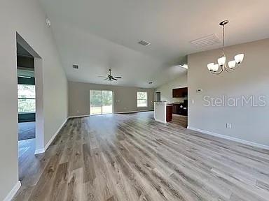 An open-concept living area features light wood-look flooring, a vaulted ceiling, and a chandelier — 3584 W BURGANDY DRIVE, CITRUS SPRINGS, FL