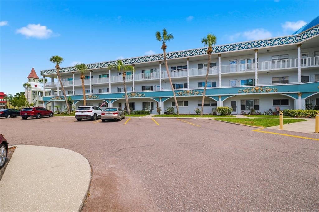 A multi-story apartment building with a blue facade and a parking lot in front — 2381 ECUADORIAN WAY UNIT 45, CLEARWATER, FL